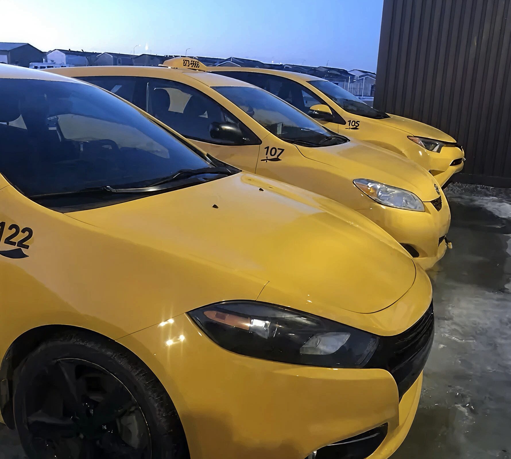 Three yellow taxi cabs parked together